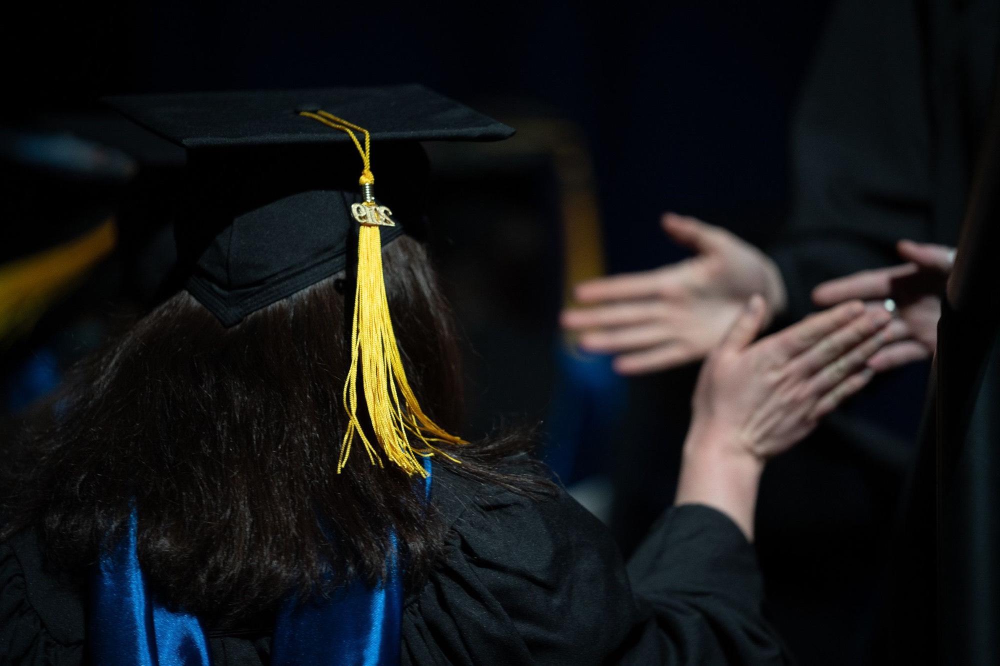 Students high five during graduation